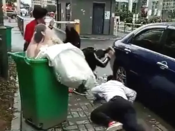 新郎抱新娘下車,不料鞭炮聲太大,新郎竟嚇得將新娘摔進了垃圾桶