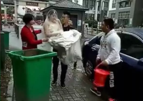 新郎抱新娘下車,不料鞭炮聲太大,新郎竟嚇得將新娘摔進了垃圾桶_