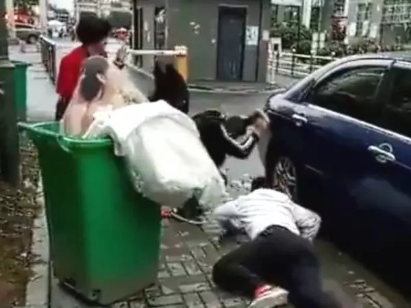 新郎抱新娘下車,不料鞭炮聲太大,新郎竟嚇得將新娘摔進了垃圾桶_