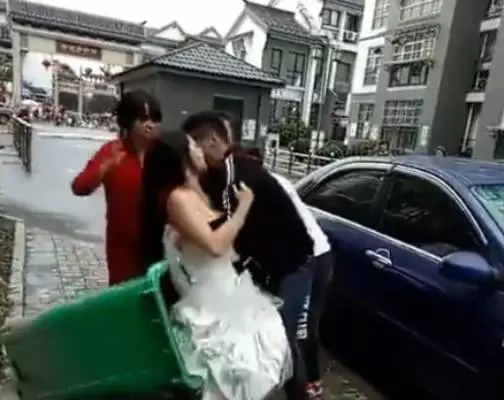 新郎抱新娘下車,不料鞭炮聲太大,新郎竟嚇得將新娘摔進了垃圾桶_