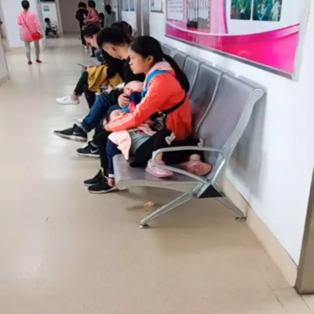 媽媽一個人抱著兩個生病的孩子,在醫院看病,為母則剛讓人心疼