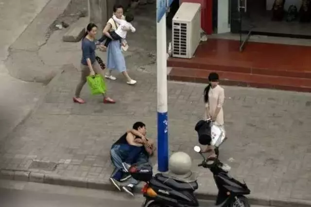 兩男子街頭緊緊抱在一起,路過女孩聽到說話後,果斷打了110
