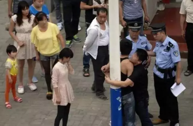 兩男子街頭緊緊抱在一起,路過女孩聽到說話後,果斷打了110
