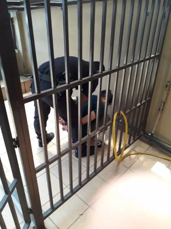 嫌犯被親人制伏後,被關進狗籠內。