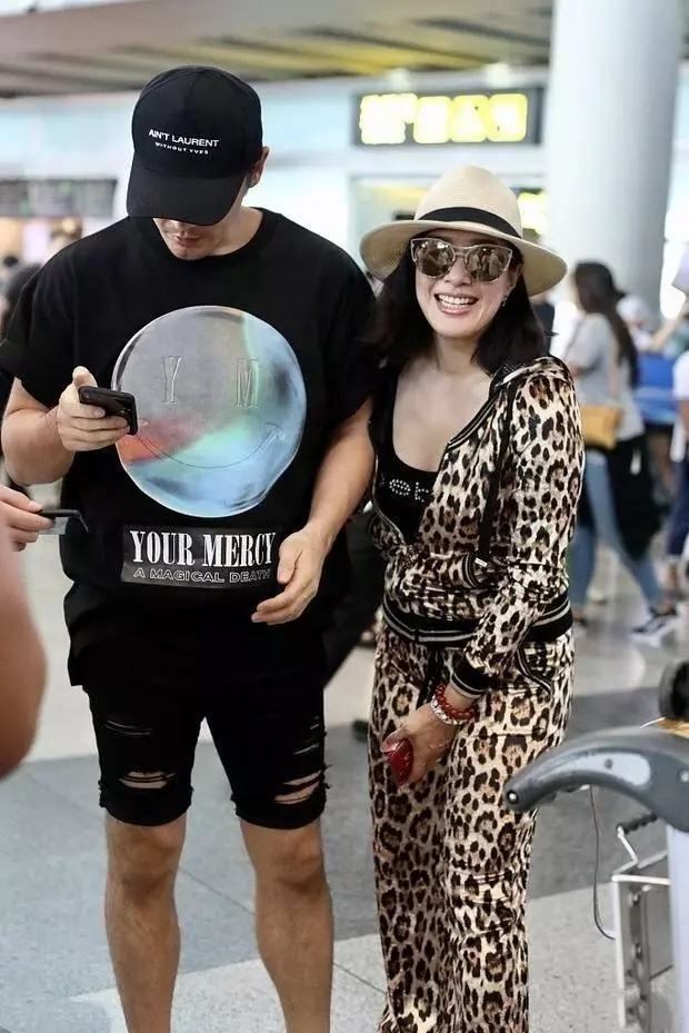 49歲鍾麗緹機場高調秀恩愛,卻被59歲婆婆搶鏡,穿格紋大衣太有范!