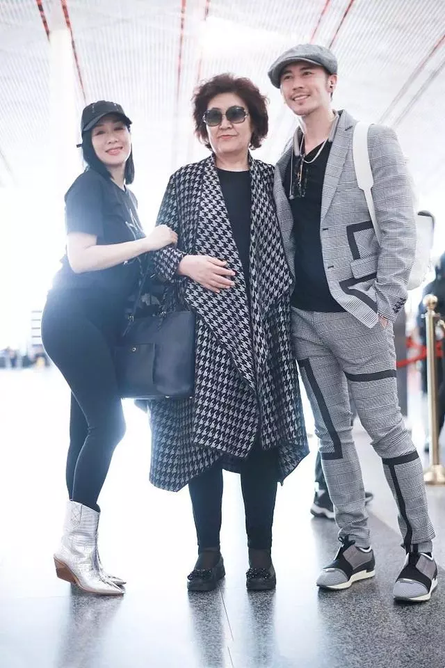 49歲鍾麗緹機場高調秀恩愛,卻被59歲婆婆搶鏡,穿格紋大衣太有范!