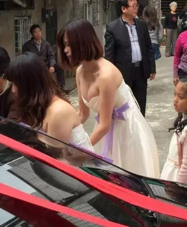 東莞伴娘穿吊帶裙,露深長事業線 。裙褂新娘變配角