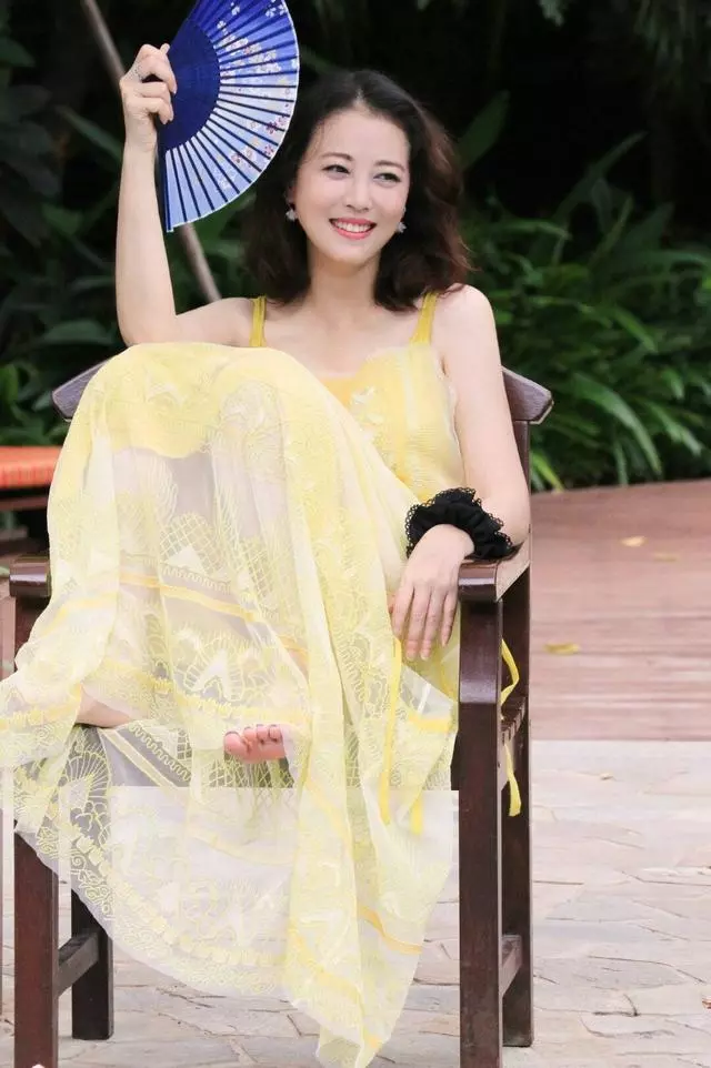 周海媚哪像52歲!一襲黃色弔帶裙太減齡,半扎丸子頭更有少女感~