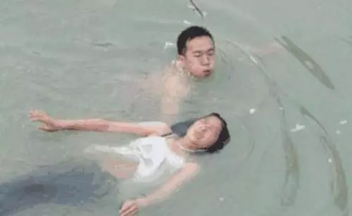 男子發現溺水女子急去搶救,遊到女子身邊,看了一眼慌忙逃離